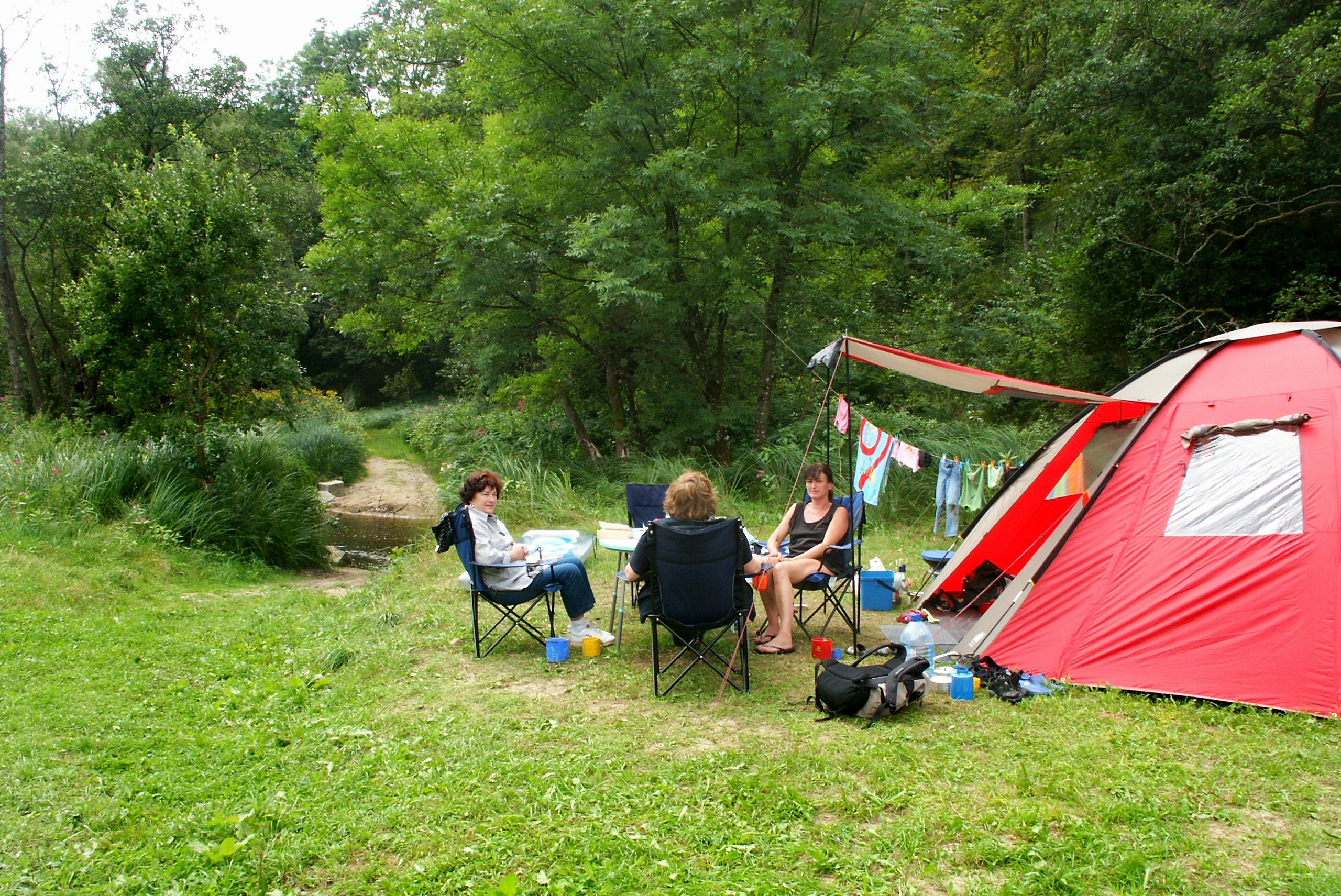 Camping Schrottenbaummühle - Familie sitzt vor einem Zelt auf dem Campingplatz