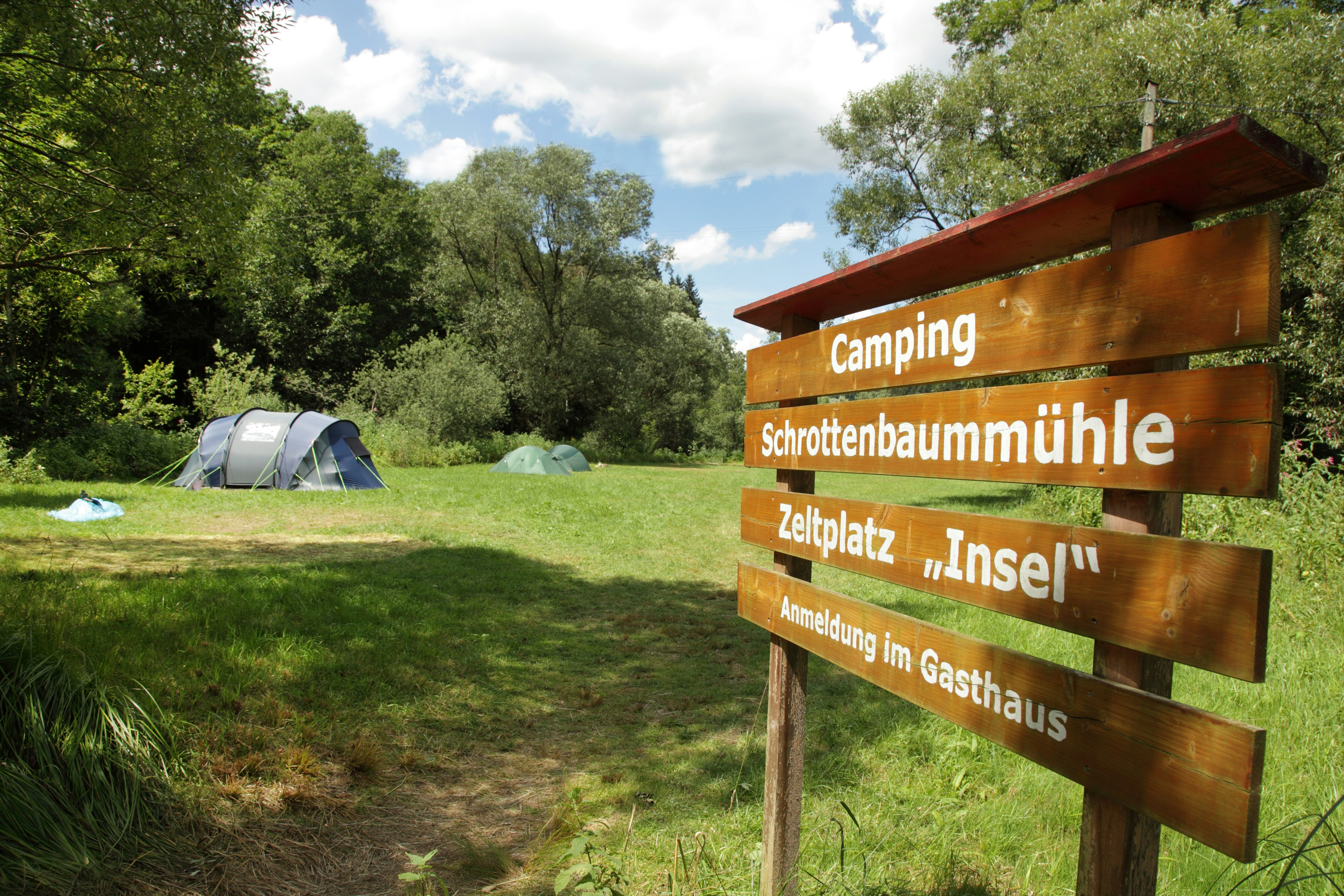 Camping Schrottenbaummühle - Wegweiser und Zeltwiese auf dem Campingplatz