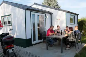 Camping Schüttehof - Camper am Esstisch auf der Terrasse vom Mobilheim auf dem Campingplatz