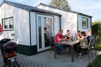 Camping Schüttehof  - Camper am Esstisch auf der Terrasse vom Mobilheim auf dem Campingplatz