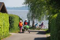 Camping Seeblick  -  Camper mit Fahrrädern und Kayak auf dem Campingplatz am Ufer des Sees