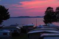 Camping Seeblick  - Blick vom Wohnwagen- und Zeltstellplatz des Campingplatzes auf den See bei Sonnenuntergang
