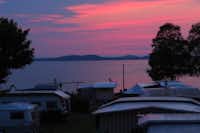 Camping Seeblick  - Blick vom Wohnwagen- und Zeltstellplatz des Campingplatzes auf den See bei Sonnenuntergang