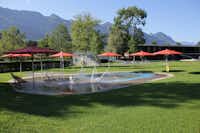 Camping Seefeld Park Sarnen  - Wasserspielplatz vom Campingplatz mit Sonnenschirmen und Berglick