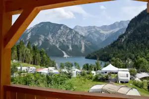 Camping Seespitze - Blick auf den See und die Stellplätze von einer Veranda eines Bungalows aus