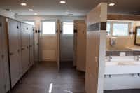 Camping Sennalpe - Innenraum des Sanitärgebäudes mit Waschbecken und Spiegeln, sowie Toilettenkabinen