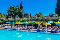 Camping Serenella - Gäste liegen am Pool in der Sonne  Pool vom Campingplatz mit LIegestühlen und Sonnenschirmen