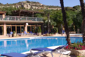 Camping Serra de Prades - Pool mit Liegestühlen und Sonnenschirmen auf dem Campingplatz