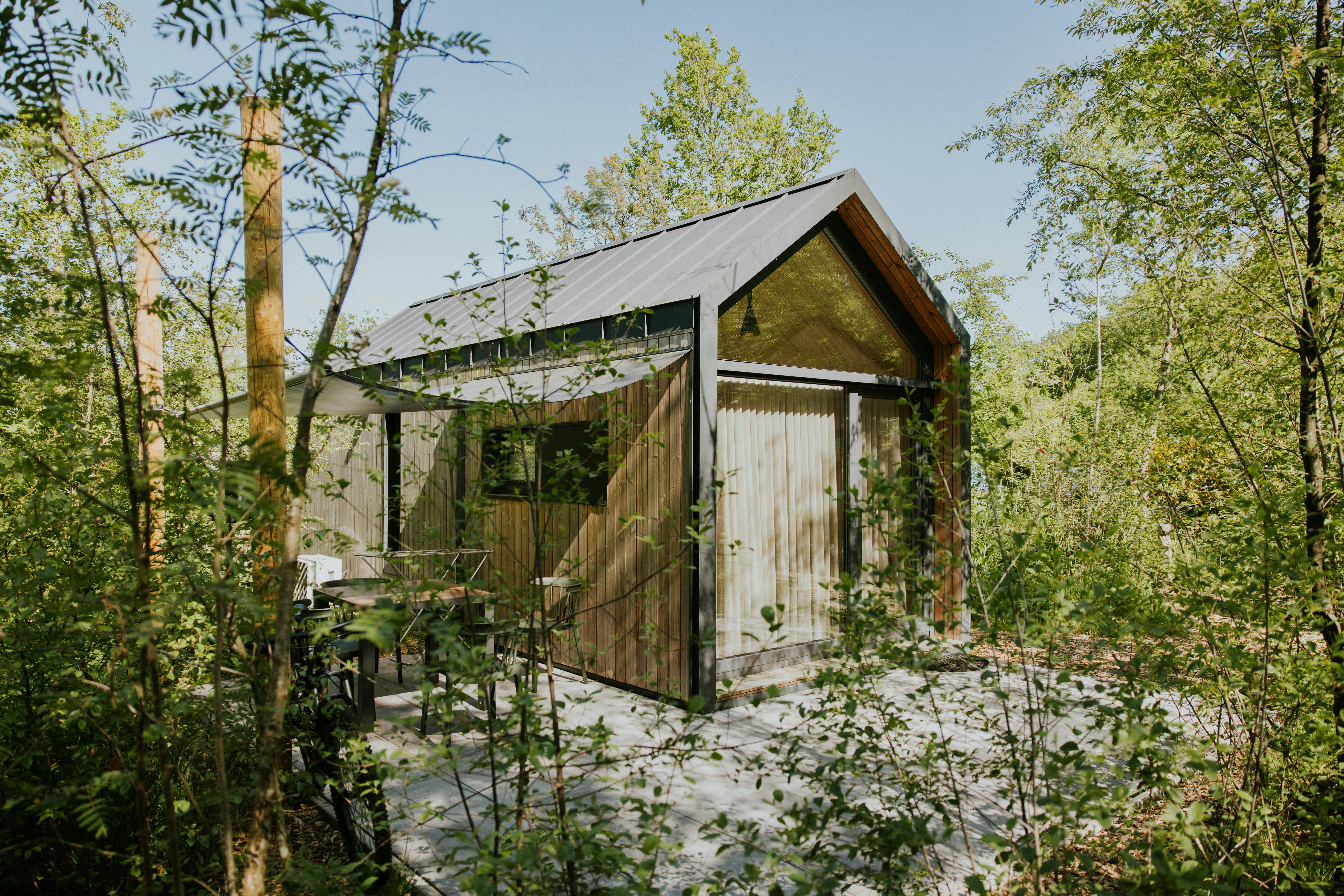 Camping Si-Es-An - Außenansicht Mobilheim zwischen Bäumen