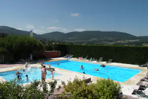 Camping Sites et Paysages Bel' Époque du Pilat - Poolbereich vom Campingplatz mit Liegestühlen in der Sonne und Blick auf den Wildpark