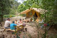 Camping Sites et Paysages Etang de Bazange - Familie auf Picknickbank vor Mobilheim auf dem Campingplatz