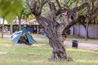 Camping Sitges - Zeltplatz und Wohnwagenbereich mit Campern vor ihrem Zelt
