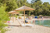 Camping Slamni -  Badestrand beim Campingplatz mit Liegestühlen und Sonnenschirmen