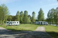 Camping Sörälgens  -  Wohnwagen und Wohnmobile auf dem Stellplatz vom Campingplatz auf grüner Wiese am See