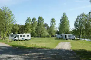 Camping Sörälgens - Wohnwagen und Wohnmobile auf dem Stellplatz vom Campingplatz auf grüner Wiese am See