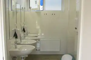 Camping Sokol Troja - Sanitärraum mit WC Kabinen Waschbecken und Spiegeln auf dem Campingplatz