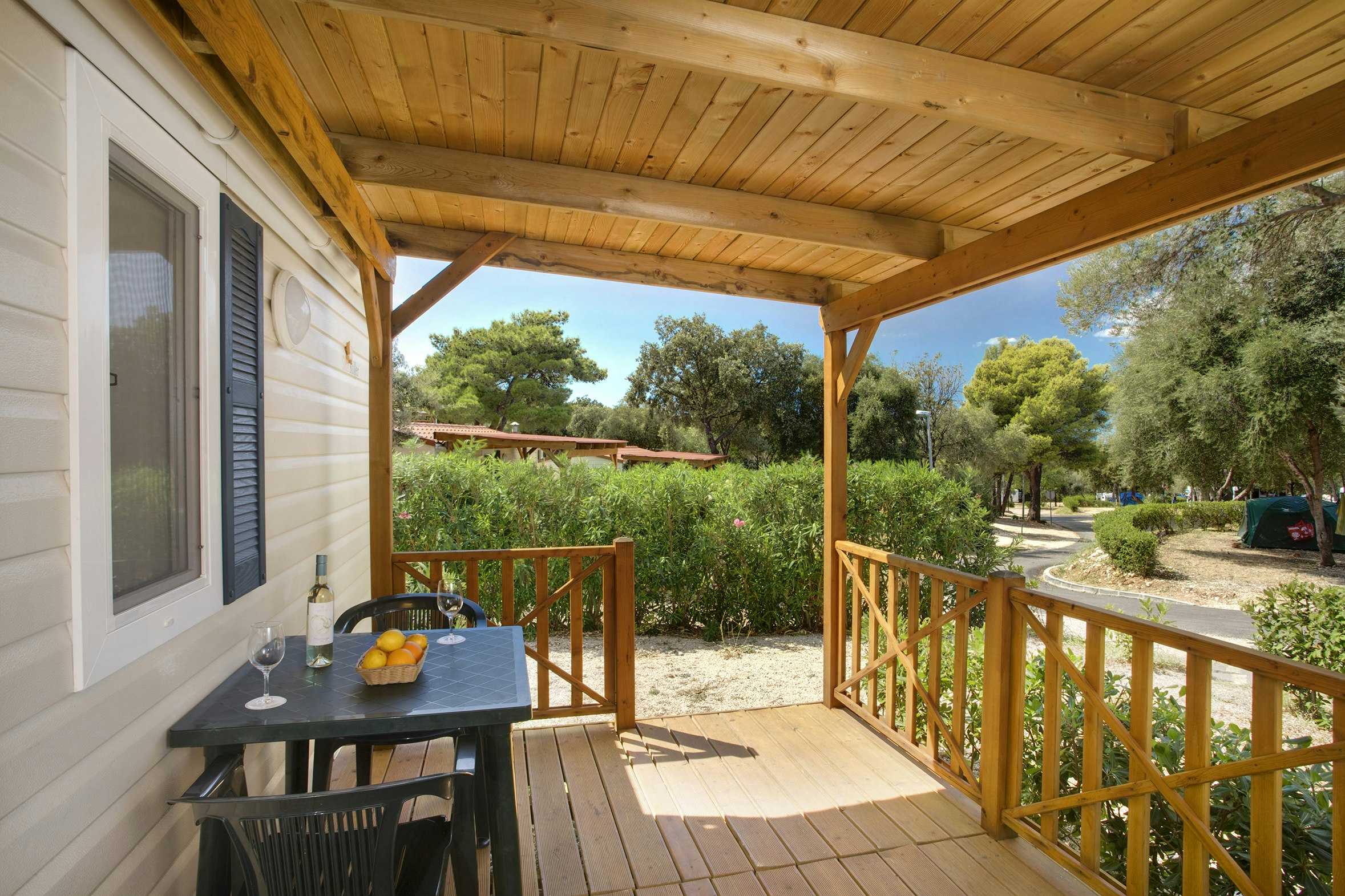 Solitudo Sunny Camping  Camping Solitudo - Überdachte Terrasse mit Esstisch eines Mobilheims