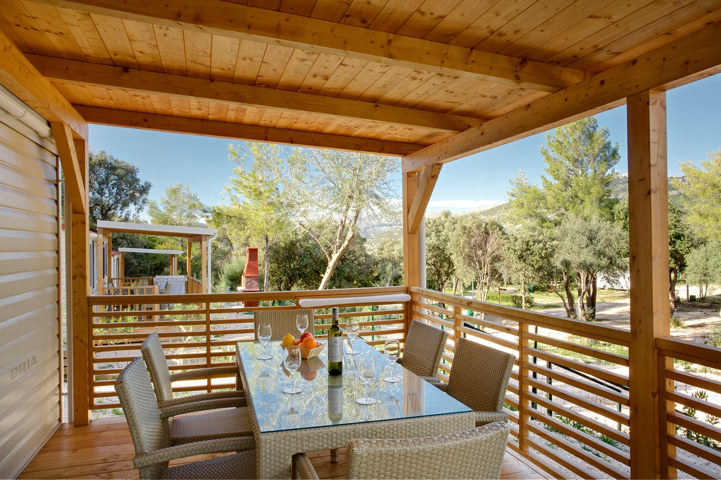 Solitudo Sunny Camping  Camping Solitudo - Überdachte Terrasse mit Esstisch eines Mobilheims