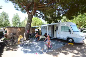 Camping & Spa CAP SOLEIL - Camper Familie am Wohnmobil auf dem Stellplatz vom Campingplatz im Schatten eines Baumes