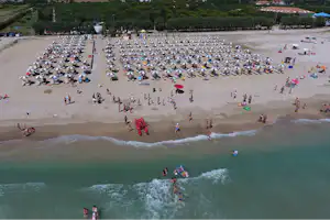 Camping Spinnaker - Strand vom Campingplatz mit Liegestühlen und Sonnenschirmen