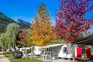 Camping St. Josef am Kalterer See - Wohnwagen- und Zeltstellplatz vom Campingplatz zwischen Bäumen mit Blick auf die Alpen