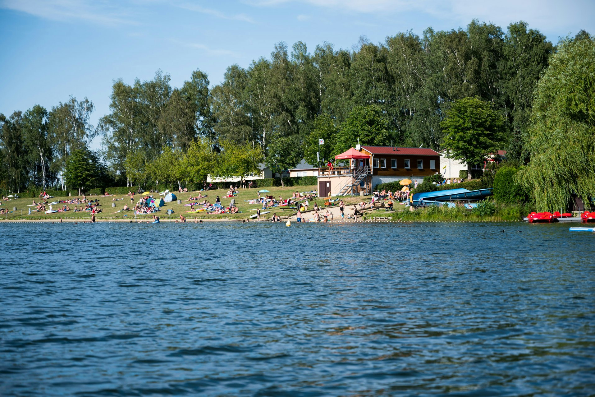 Camping Stausee Oberwald - Blick auf den See mit Badestrand und Liegewiese