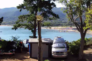 Camping Stella Mare - Wohnmobil mit Vorzelt auf dem Campingplatz mit dem Mittelmeer im Hintergrund