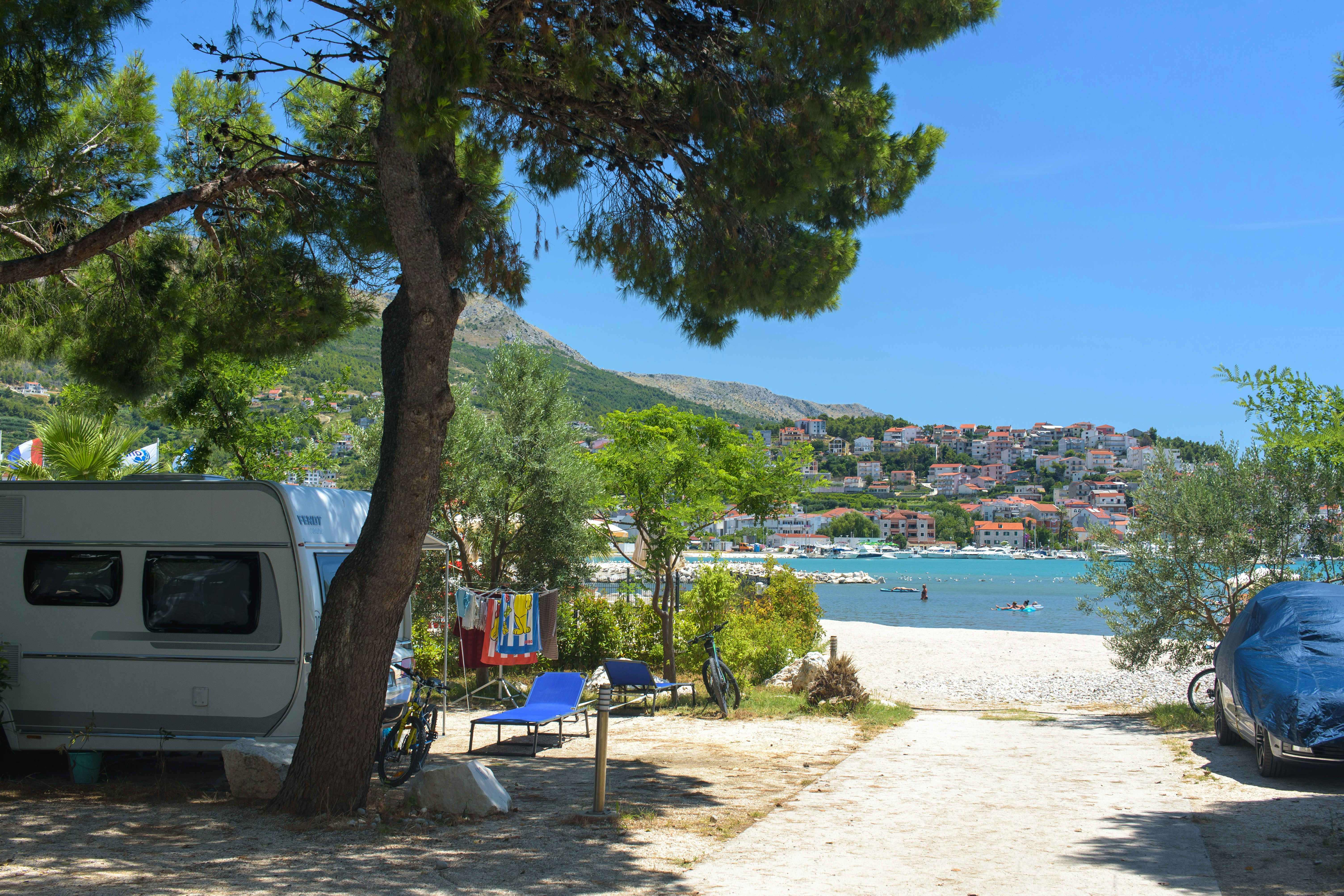 Camping Stobreč Split - Wohnmobil- und  Wohnwagenstellplätze im Schatten der Bäume mit Blick auf das Meer