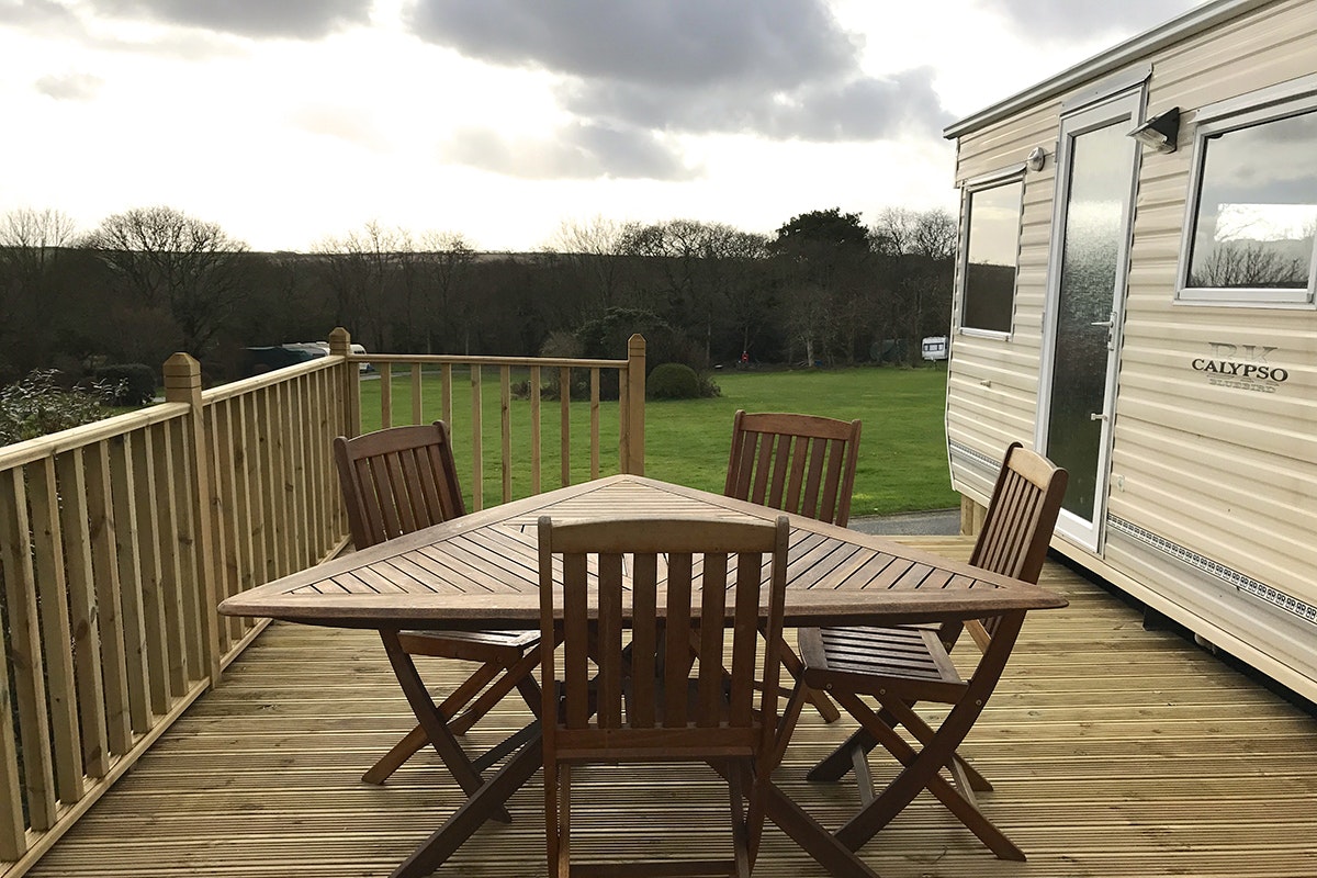 Camping Summer Valley - Veranda eines Mobilheims mit Holztisch und Stühlen