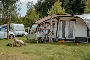 Ardoer Camping 't Geuldal - Familie sitzt gemeinsam auf ihrem Standplatz