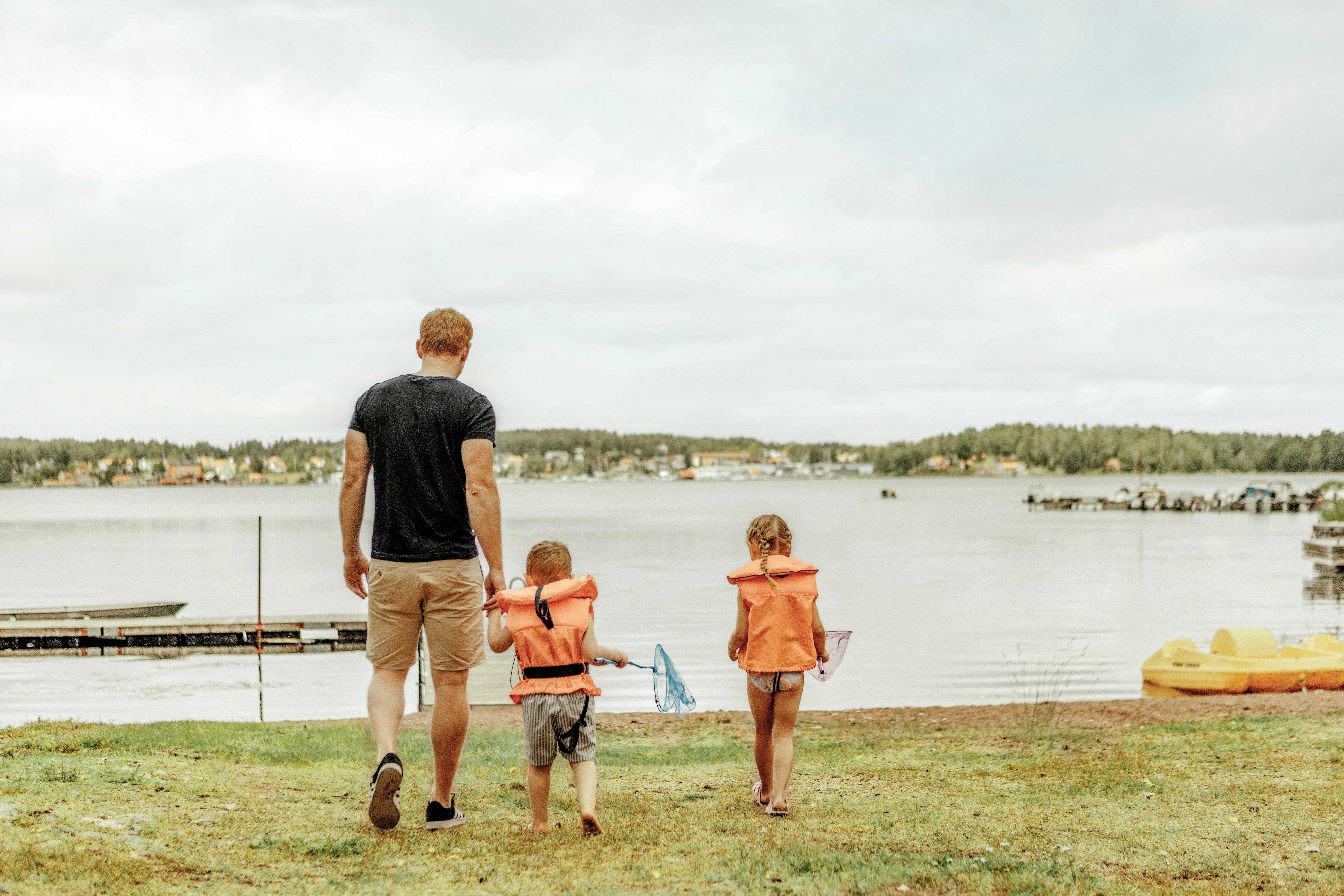 Camping Tättö Havsbad - Vater mit Kindern auf dem Weg zum Badestrand am See
