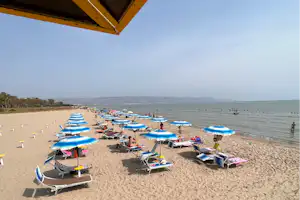 Camping Tellina Agriturismo SNC - Blick auf den Badestrand mit Liegestühlen und Sonnenschirmen