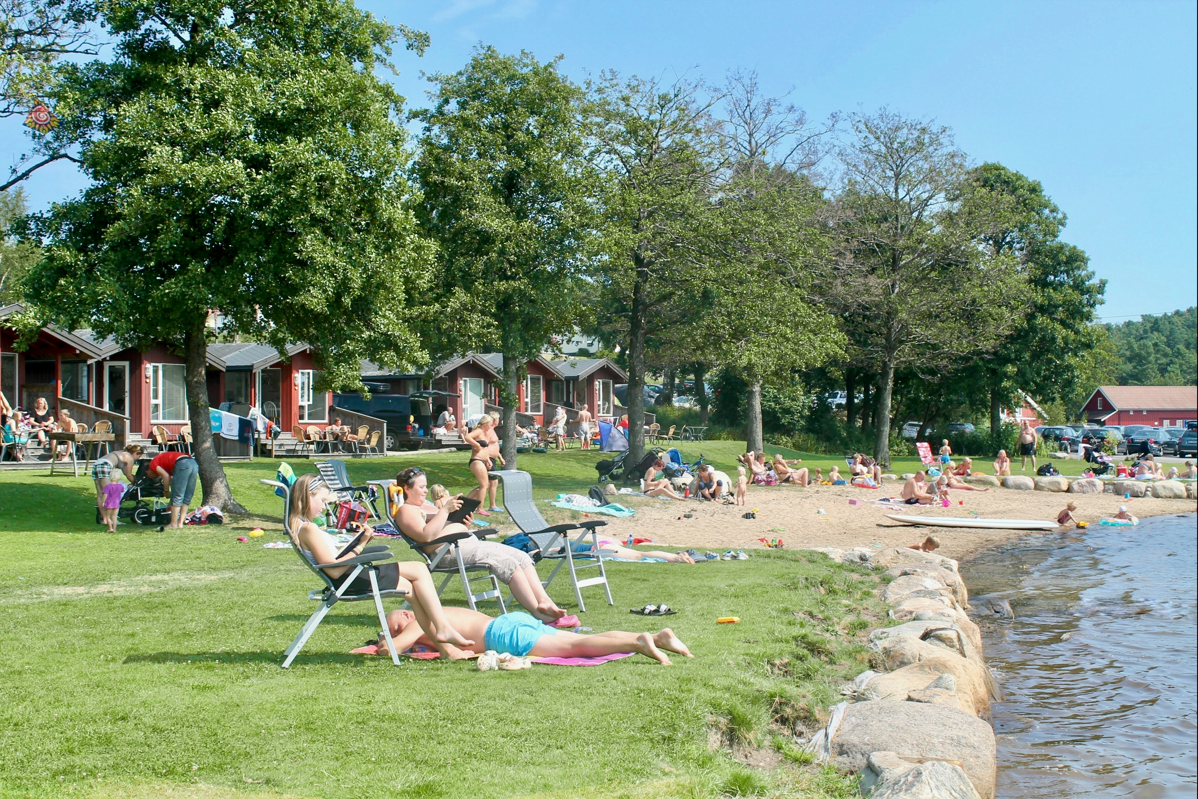 Tingsaker Camping - Gäste entspannen auf der Liegewiese am Badestrand