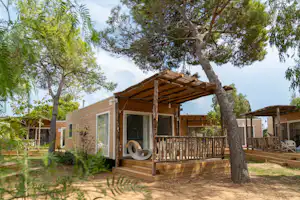 Sandaya Camping Toscana Bella - Außenansicht eines Mobilheims mit Terrasse auf dem Campingplatz