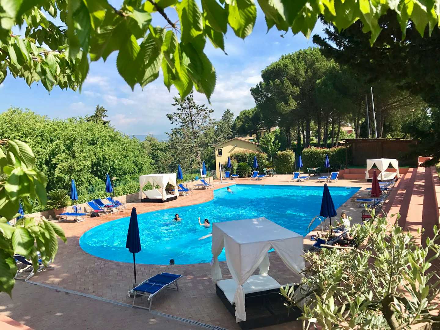 Camping Toscana Village - Pool mit Liegestühlen und Sonnenschirmen auf dem Campingplatz 