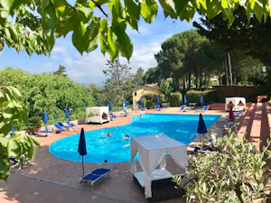 Camping Toscana Village - Pool mit Liegestühlen und Sonnenschirmen auf dem Campingplatz