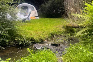 Camping TroDoWay - Blick auf einen Zeltplatz direkt am Bach