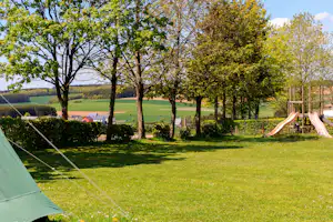 Camping Um Bierg - Stellplatzwiese mit Kinderspielplatz im Hintergrund