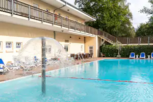 Camping- und Ferienpark Markgrafenheide - Pool im Freien mit Liegestühlen und Sonnenschirmen