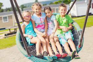 Camping- und Ferienpark Orsingen - Kinder auf einer Schaukel vom Spielplatz auf dem Campingplatz