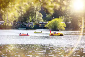 Camping- und Ferienpark Teichmann - Camper mit Booten auf dem Teich am Campingplatz, Stellplatz im Hintergrund