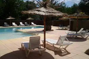 Camping Universal - Swimmingpool mit Liegestühlen und Sonnenschirmen am Rand