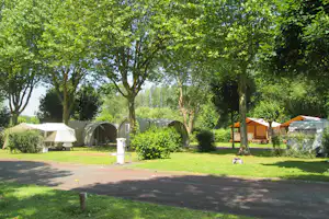 Camping Val de Boutonne - Blick auf den Stellplatz des Campingplatzes mit Glampingzelten zwischen Bäumen