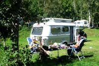 Camping Val di Sole - Wohnwagenstellplatz mit Campingtisch und Campingstühle im Schatten