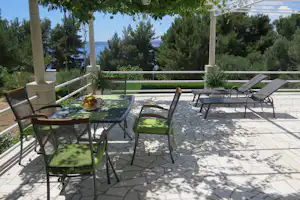 Camping Vala - Terrasse vom Mobilheim mit Esstisch und Liegestühlen auf dem Campingplatz mit Blick auf das Mittelmeer