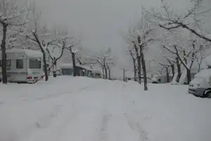 Camping-Valira - Schneebedeckte Wohnwagen in winterlicher Berglandschaft