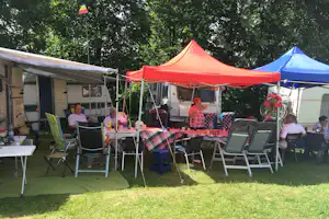 Camping Vampire - WOhnwagen und Pavillon mit sitzenden Campern auf dem Campingplatz