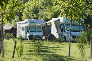 Camping Verneda - Wohnmobilstellplatz zwischen Bäumen auf dem Campingplatz