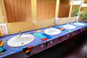 Camping Via Claudia Augusta - Sanitärgebäude mit Waschbecken, Spiegel und Toiletten