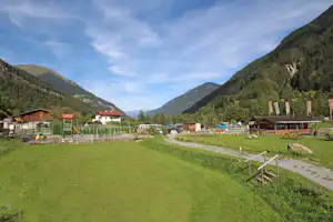 Camping Via Claudiasee - Stellplätze des Campingplatze mit einem Kinderspielplatz im Hintergrund